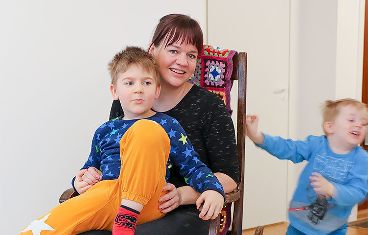 Teija Rautio iloitsee vertaistuesta, jota Perheentalossa on tarjolla. Äidin sylissä istuu Daniel-poika ja vauhtia antaa pikkuveli Oliver.
