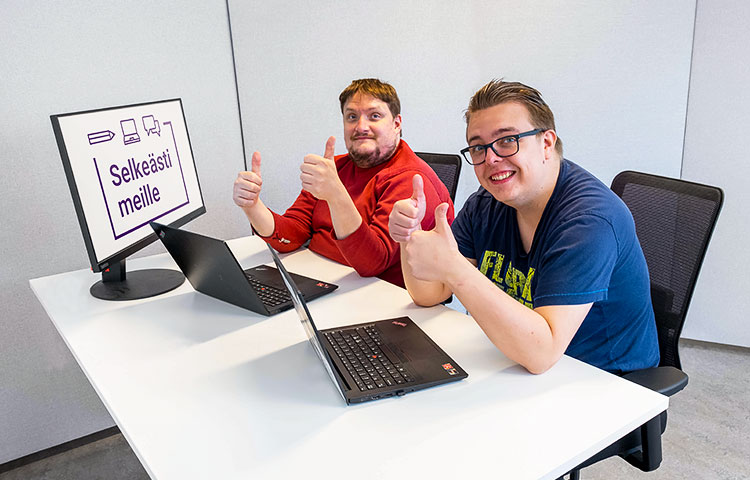 Kaksi miestä ja kaksi kannettavaa tietokonetta.