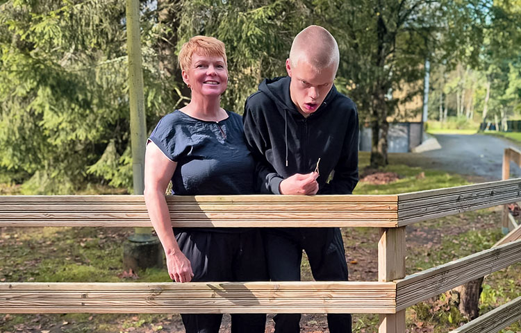 Nainen ja nuori mies vierekkäin, takana pihamaa.