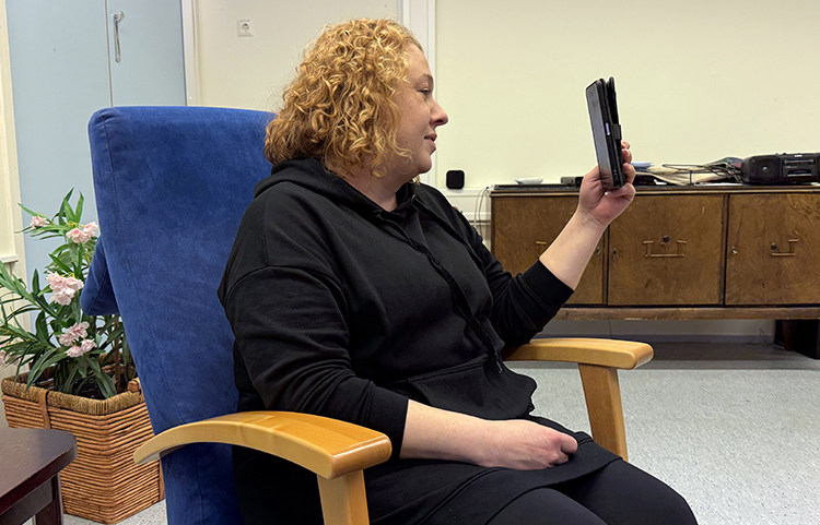 Nainen katsoo puhelimen näyttöruutua.