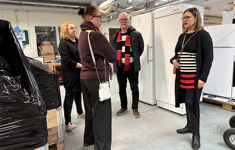 Neljän henkilön ryhmä seisoo keskustelemassa.