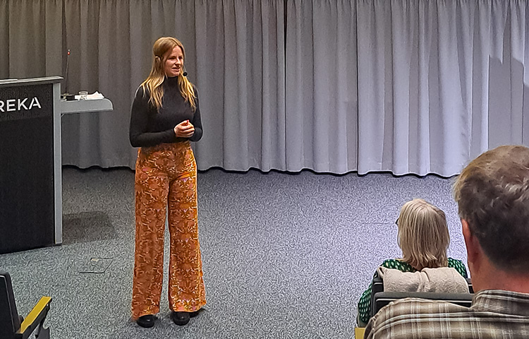 Elsa Havas luennoimassa yleisölle, yleisöstä näkyy muutama henkilö takaapäin.