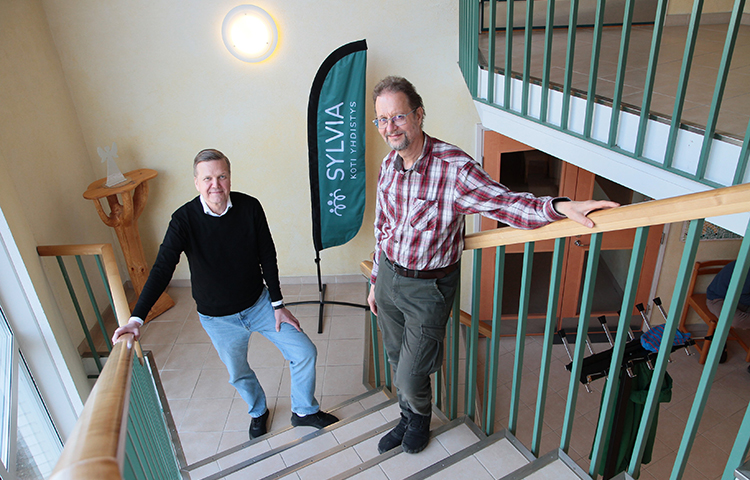 Kaksi miestä seisoo rappusissa.